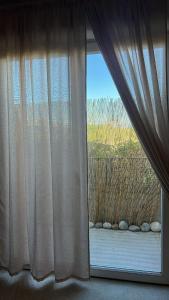 a window with curtains and a view of a yard at Charming apartment with terrace and parking in Carcassonne in Carcassonne