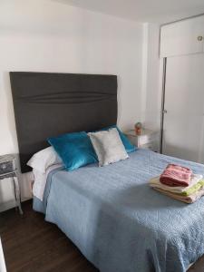 a bedroom with a bed with blue and white pillows at Jupiter Estudio in Benalmádena +16 photos
