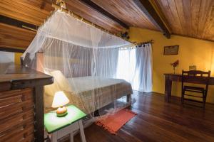 a bedroom with a bed with a net over it at Canoa Nativa Pousada Boipeba in Ilha de Boipeba +57 photos
