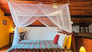 a bedroom with a bed with a canopy at Canoa Nativa Pousada Boipeba in Ilha de Boipeba