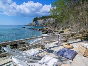 kilka krzeseł i stół na plaży w obiekcie Beachfront Villas on Crete - Pelagaios w mieście Ferma