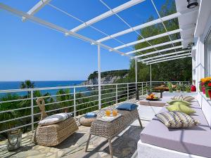 eine Terrasse mit einem Tisch, Stühlen und Meerblick in der Unterkunft Beachfront Villas on Crete - Pelagaios in Ferma