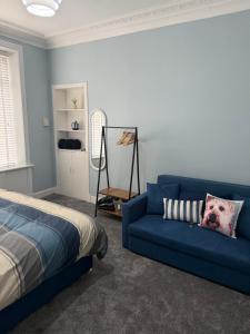 StevenstonにあるWoodside Bungalowのベッドルーム(青いソファ、ベッド付)