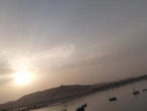 a sunset over the ocean with boats in the water at اسوان مول بلازا in Aswān