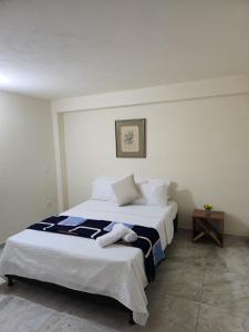 a bedroom with two beds with white sheets and a table at Casa completa Comodidad-Ubicación Perfecta-CarmenV in Carmen de Viboral