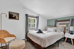 een slaapkamer met een bed, een stoel en een raam bij Tranquil Trails Cottage Fire Pit Cozy 3BDR in Gouldsboro +11 foto's