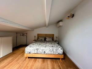 Marseille chateau gombert duplex studio au pied des collines في مارسيليا: غرفة نوم مع سرير وأرضية خشبية