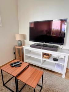 Marseille chateau gombert duplex studio au pied des collines في مارسيليا: مركز ترفيه ابيض مع شاشة تلفزيون مسطحة كبيرة