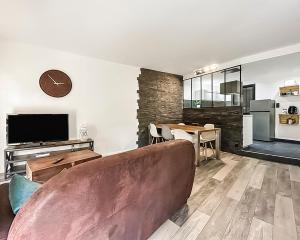 a living room with a couch and a table at Élégant T3 à deux pas du centre ancien in Arles