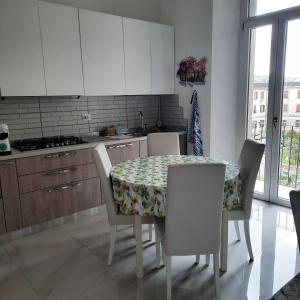 a kitchen with a table and chairs and a kitchen with white cabinets at Wellness at home in Ancona