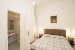 Un dormitorio con una cama y un baño con lavabo. en Suites Ansidei - Acquedotto, en Perugia