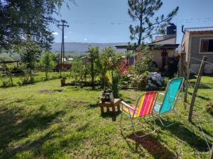 two chairs and a table in a yard at Cabañas Megustayacanto in Villa Yacanto
