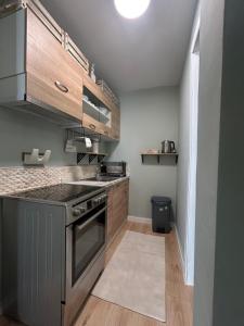 a kitchen with wooden cabinets and a stove top oven at Xylokastro Central Apartment in Xylokastron