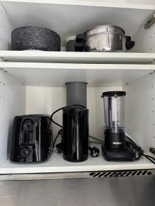 a kitchen shelf with various appliances on it at Charmant studio à 5 min de la Gare du Midi, 1-2 pe in Mellet +14 photos