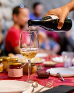 テラヴィにあるRostomaant Marani Family Winery Guest House, Telaviのワインをテーブルの上に注ぐ者 +1枚の写真