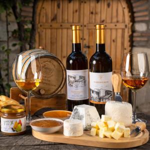 two bottles of wine and cheese on a table with wine glasses at Rostomaant Marani Family Winery Guest House, Telavi in Tʼelavi