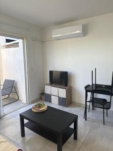 Saint-Orens-de-GamevilleにあるAppartement climatisé Saint Orens N8のリビングルーム(黒いテーブル、テレビ付)