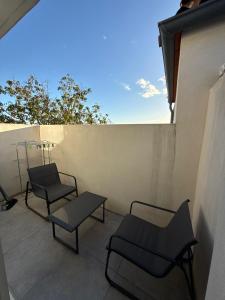 Saint-Orens-de-GamevilleにあるAppartement climatisé Saint Orens N8のバルコニーに椅子2脚とテーブル1台