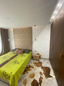 a bedroom with a bed with a green comforter at Fort View Apartment in Kelibia