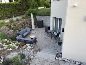 a patio with a couch and a table and an umbrella at Terrassenwohnung mit Parkplatz in Wangen