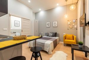 een slaapkamer met een bed en een gele stoel bij A57- Boutique Apartments, Best Location, by BQA in Boedapest