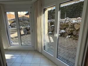 an empty room with doors to a patio at Terrassenwohnung mit Parkplatz in Wangen