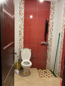 a bathroom with a toilet in a red wall at A nice appartement a louer temara in Temara