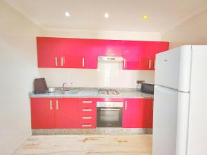 a kitchen with red cabinets and a white refrigerator at les Belles Sejours in Tangier