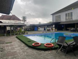a swimming pool with two life rafts in the middle at Leadwort Hotel in Rumu-Epeni