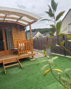 un cenador con un banco en un patio en La Galipette, charmant chalet en Champagne, en Fleury-la-Rivière