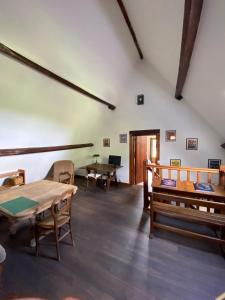 a room with tables and chairs in a building at Charmante longère percheronne avec cheminée, jacuzzi et verger in Charbonnières
