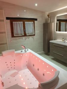 a pink bath tub in a bathroom with a sink at Charmante longère percheronne avec cheminée, jacuzzi et verger in Charbonnières +48 photos