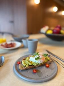 a piece of toast with eggs on a plate on a table at Door9 Hasselt - Digital Hotel in Hasselt