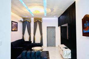 a living room with a couch and a door at Rondawel Luxury 2 Bedroom Apartment, Lekki VGC in Lekki