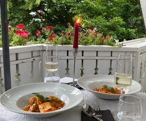 a table with two plates of food and glasses of wine at Nido Vela Appartement in Wesseling