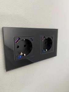 a switch on a wall with two lights on it at Nido Vela Appartement in Wesseling