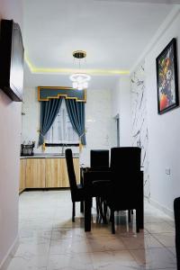 a dining room with a black table and chairs at Rondawel Luxury 2 Bedroom Apartment, Lekki VGC in Lekki