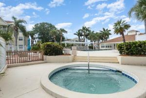 una vasca idromassaggio in un cortile con palme di Ground Floor 2 Bdrm King Condo Close to Beach a Melbourne