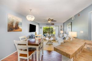 una sala da pranzo e un soggiorno con tavolo e sedie di Ground Floor 2 Bdrm King Condo Close to Beach a Melbourne
