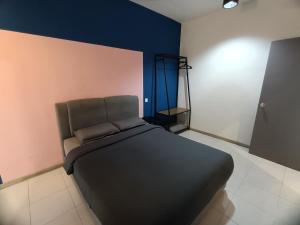 a bedroom with a black bed in a room at Premium Look Homestay in emerald avenue apartment Clover Home 5-06 in Brinchang