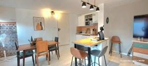 eine Küche und ein Esszimmer mit Tisch und Stühlen in der Unterkunft Le "Therdon'Oise" - Maison, gardiennage & navette in Therdonne