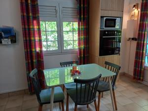 a kitchen with a table and chairs in a kitchen at le colibri ble in Sainte-Anne