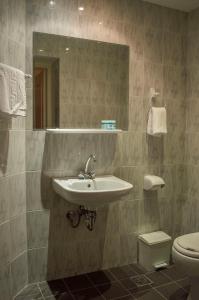 een badkamer met een wastafel en een toilet bij Hotel Oiti in Loutra Ipatis