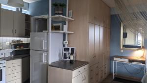 a kitchen with a white refrigerator and white cabinets at Leo's home in Ioannina
