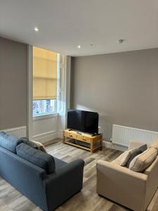 a living room with two couches and a flat screen tv at George IV Bridge Suite in Edinburgh