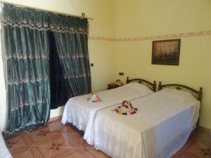 two beds in a room with green curtains at Tahla Garden in Tahla +121 photos