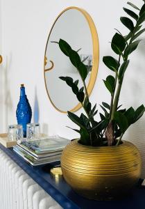 a gold vase sitting on a table with a mirror at Le 8 in Mutzig