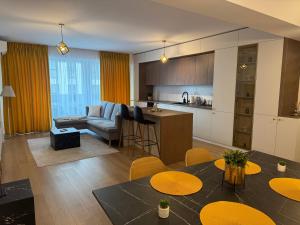 a kitchen and a living room with a table and chairs at ABE Apartment in Craiova
