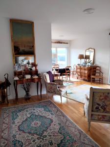 a living room with chairs and a table and a rug at Chambre d'hôtes Coeur de Maine in Angers