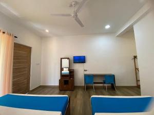 a room with two blue chairs and a table at Grandmila Resort in Anuradhapura